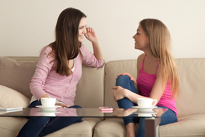 Mother and daughter talking on a couch