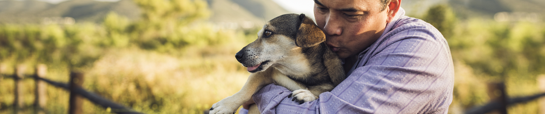 man holding his dog in arms with great affection