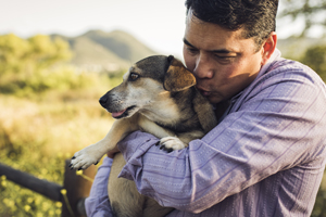 man holding his dog in arms with great affection