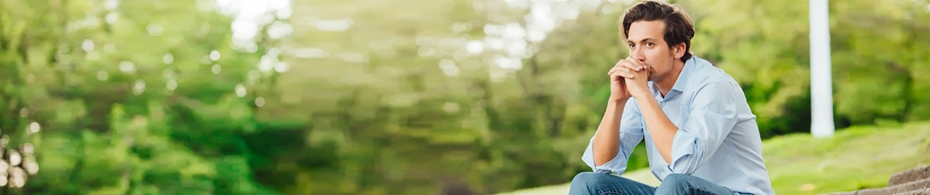 man sitting on stone steps in park like area