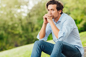 man sitting on stone steps in park like area