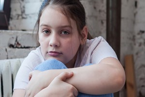 Pre-teen looking directly at camera with pensive eyes